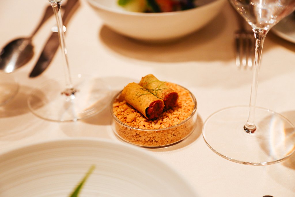 Sticky satay sauce with a lingering spice rolls on a bed of crushed peanuts