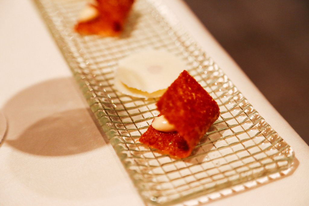 Green apple puck between two thin almond discs and crispy brioche with a hay cream